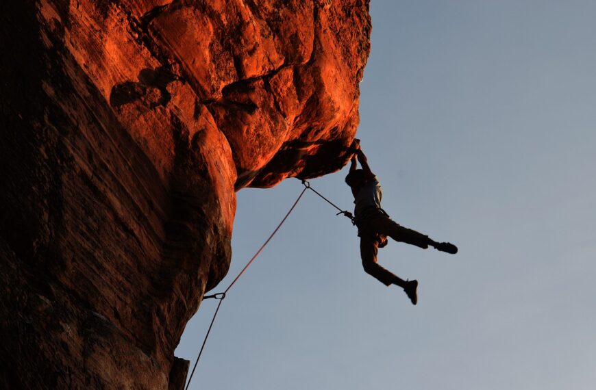 Foto de un escalador subiendo una vía de escalada deportiva